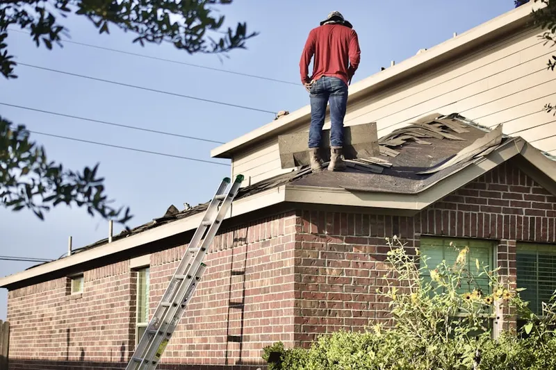Professional roofer working on a residential roof in Windy Hill Manor